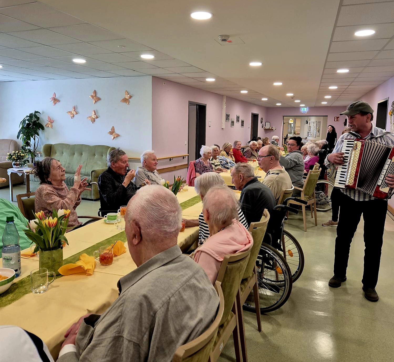 Bewohner*innen des Pflegeheims mit Musikant