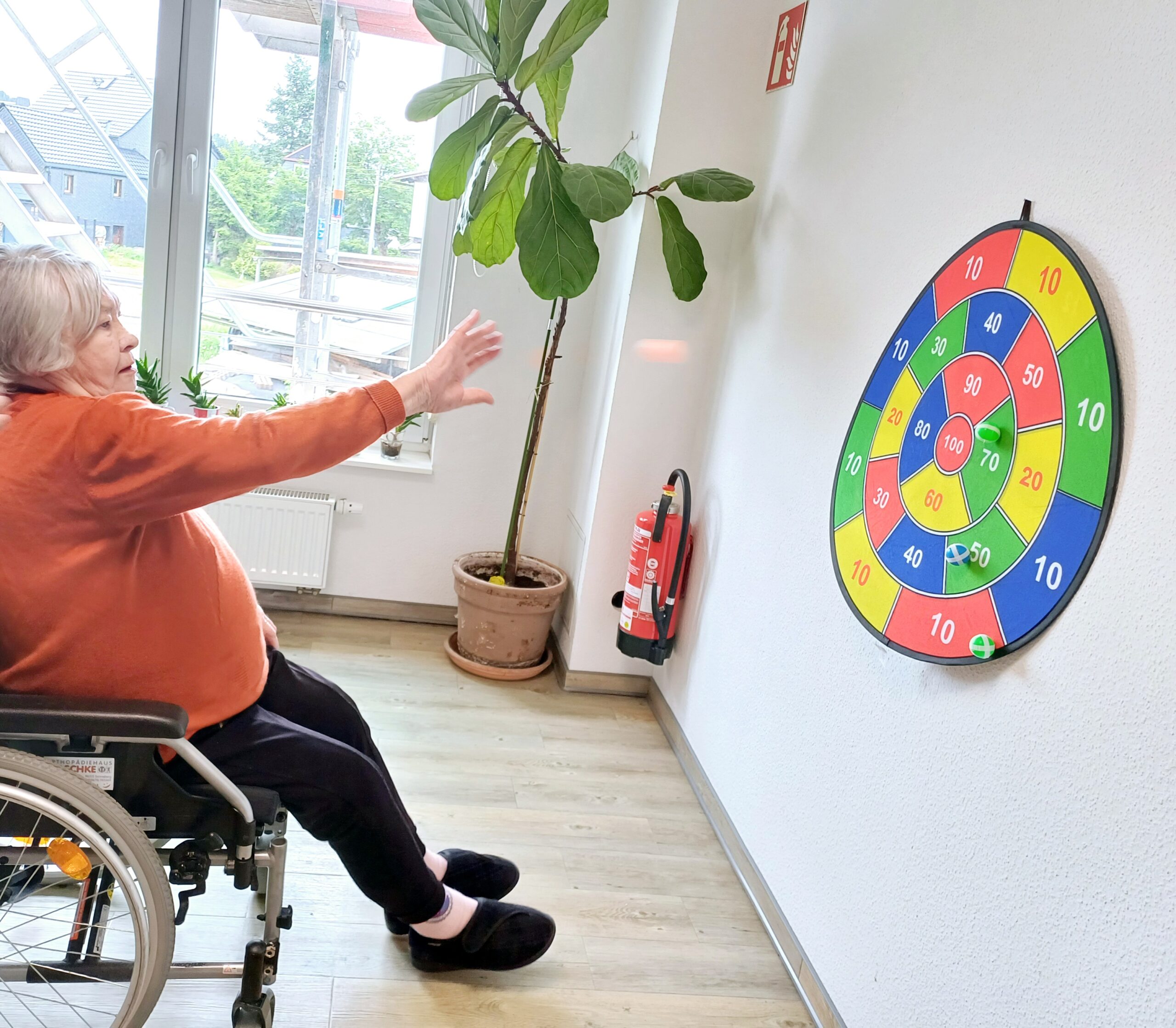 eine Bewohnerin wirft auf eine Zielscheibe