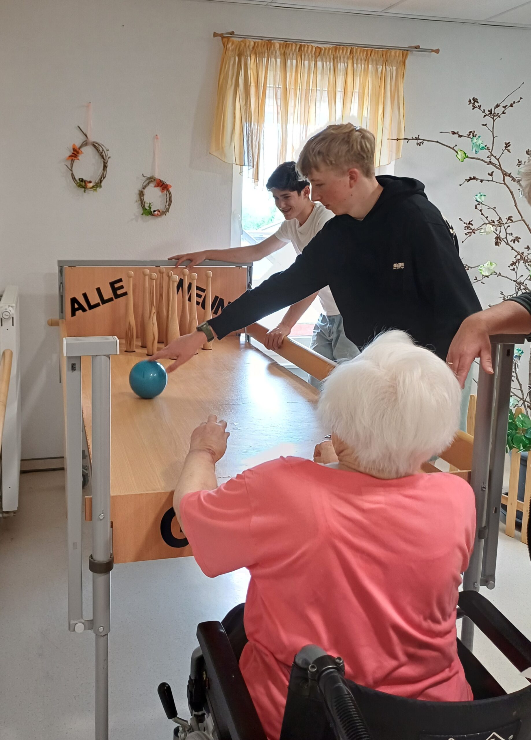 die Schüler spielen mit einer Bewohnerin kegeln